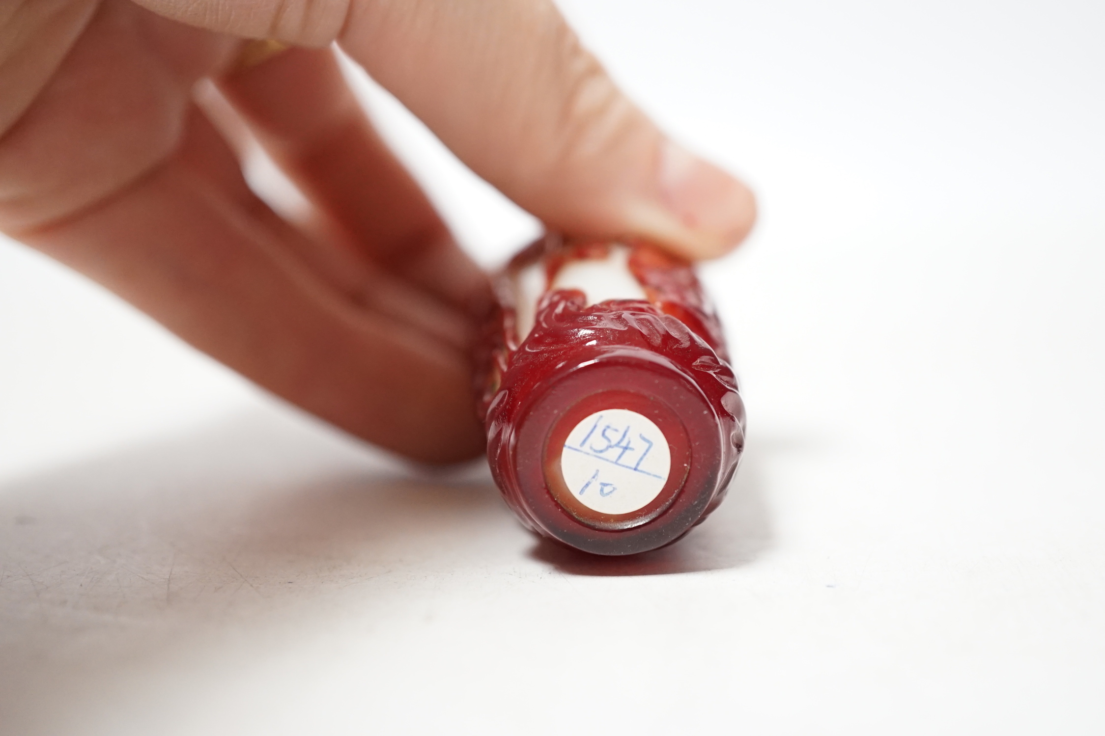 A Chinese ruby and white opaque glass erotic snuff bottle, early 20th century, 8cm high